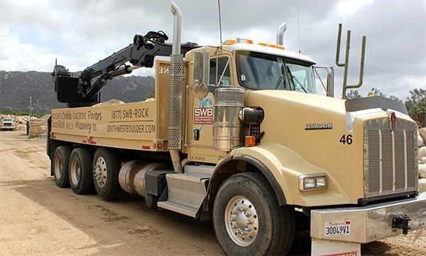 Southwest Boulder & Stone branded truck with attached crane used to place and position boulders