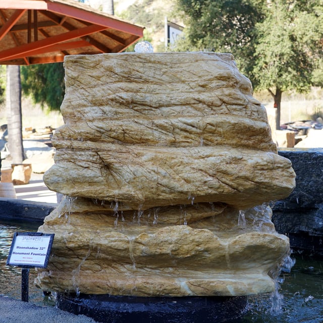 Moonshadow Natural Boulder Fountain displayed in pond for sale at rock yard