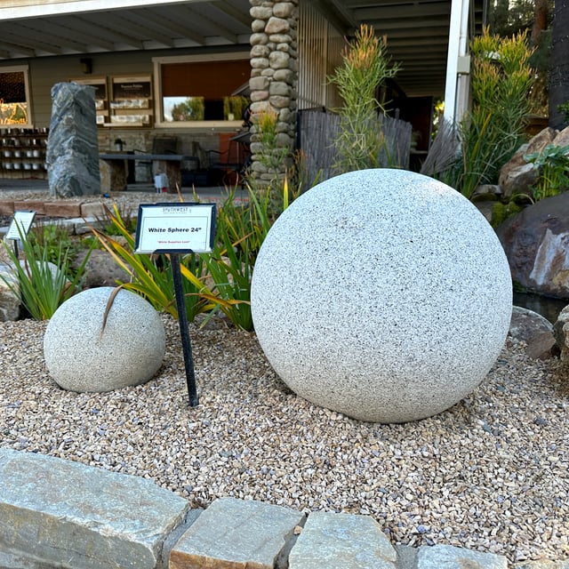 White Granite Sphere on crushed rock in rock yard