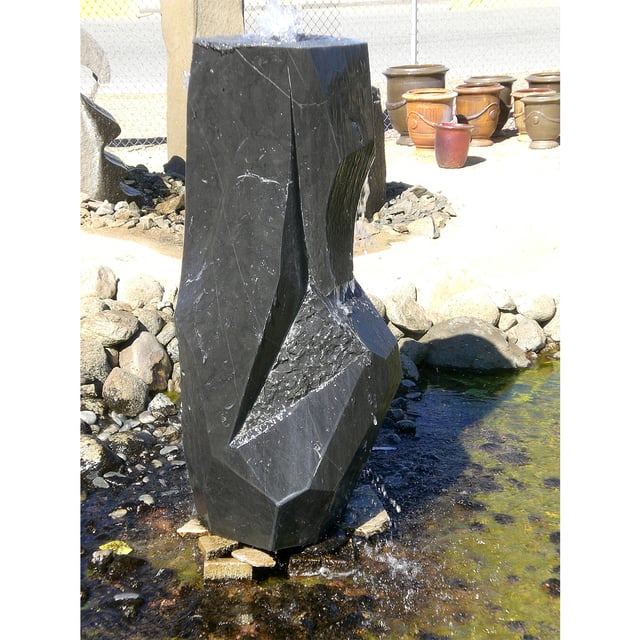 Mizubachi polished black custom stone fountain installed in rock pond at rock yard