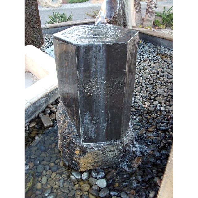 Dark Marble Hexagon Stone fountain installed in water pond with pebbles
