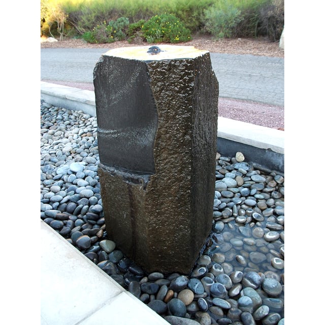 Basalt even flow stone fountain installed with surrounding pebbles 
