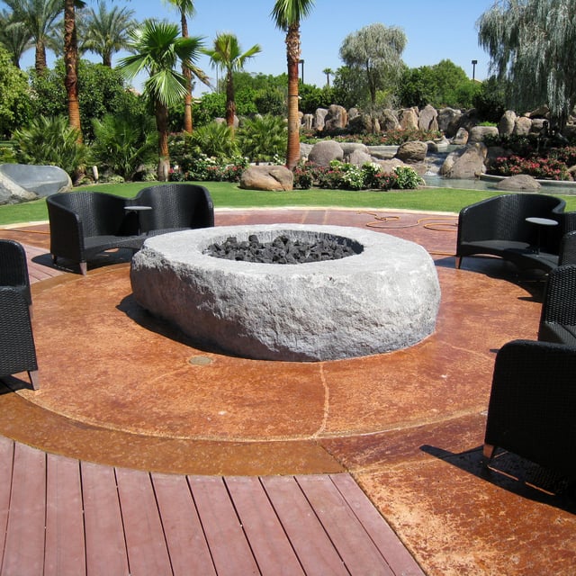 Custom granite stone fire pit installed in backyard patio