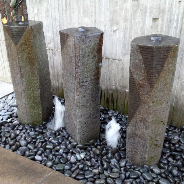 Three sisters custom stone fountain installed over mexican beach pebble